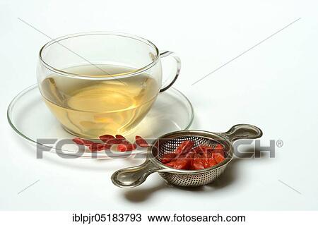 Stock Image - Fenugreek-tea in tea cup, in tea strainer (Lycium barbarum), cup, tea strainer, tea. Fotosearch