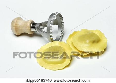 Stock Image - Fresh ravioli with ravioli cutter, pasta, cookie cutter. Fotosearch