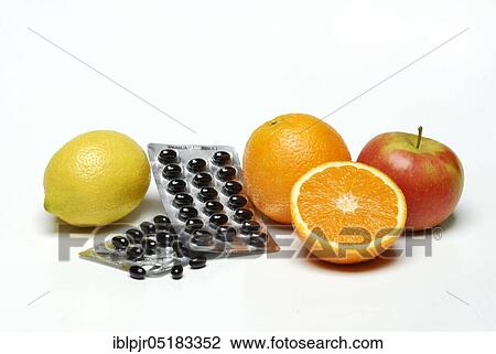 Stock Image - Fruit and food supplements, orange, lemon, apple, dragées, deficient food. Fotosearch