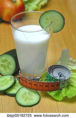 Stock Photography - Glass of buttermilk, cucumber, lettuce leaf, milk, straw, lettuce, lettuce, cucumber, measuring tape. Fotosearch