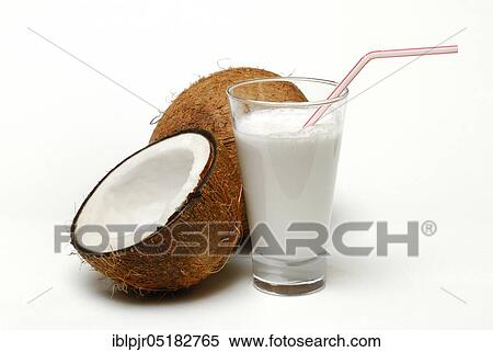 Stock Photography - Glass of coconut milk, halved coconut, drinking straw, coconut milk. Fotosearch