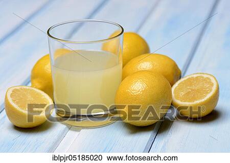 Stock Image - Glass of lemon juice with lemons. Fotosearch
