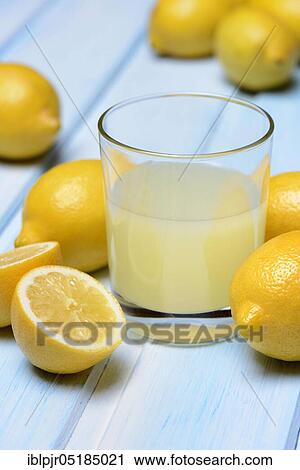 Glass of lemon juice with lemons View Large Photo Image Stock Image - Glass of lemon juice with lemons. Fotosearch