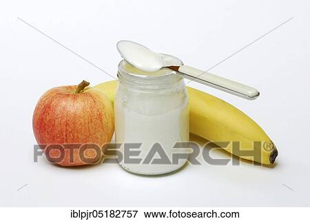 Stock Photo - Glass of yoghurt, apple and banana, dairy products, spoon. Fotosearch