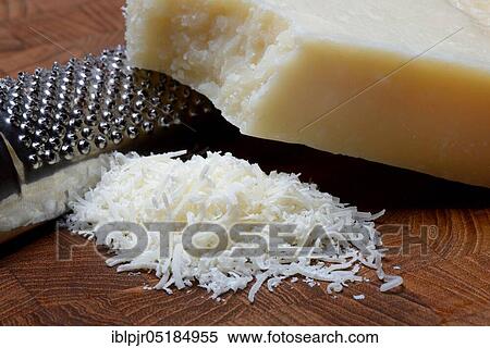 Stock Photography - Grated Parmesan cheese and piece of Parmesan cheese, Parmigiano Reggiano. Fotosearch