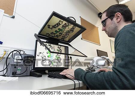 Stock Photograph - Heinrich-Heine-University, Theoretical Pharmacy Group Prof. Gohlke, PhD student at 3D monitor with 3D mouse, Düsseldorf, Germany, Europe. Fotosearch