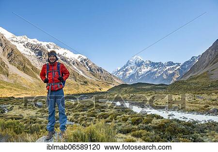 Hiker standing on a rock, Hooker Valley overlooking snow-capped Mount Cook, Hooker River, snow-capped Mount Cook National Park, Southern Alps, Canterbury, South Island, New Zealand, Oceania View Large Photo Image Stock Image - Hiker standing on a rock, Hooker Valley overlooking snow-capped Mount Cook, Hooker River, snow-capped Mount Cook National Park, Southern Alps, Canterbury, South Island, New Zealand, Oceania. Fotosearch
