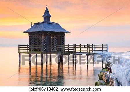 Stock Image - Iced bathhouse at sunrise, Lake Neuchâtel, Gorgier, Neuchâtel, Switzerland, Europe. Fotosearch