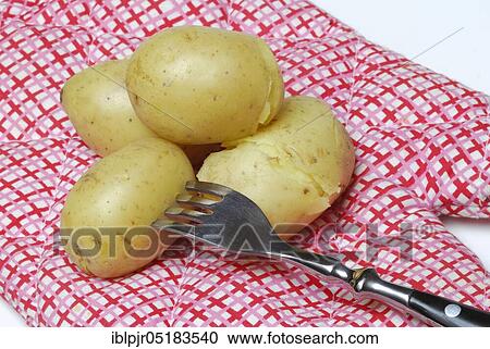 Stock Image - Jacket potato with fork, potatoes, boiled, cooked. Fotosearch