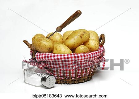 Stock Image - Jacket potatoes in basket and salt shaker, cooked. Fotosearch
