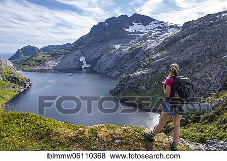 Stock Photo - Lake Fjerddalsvatnet, hiker on the way to Munkebu cabin, mountains, near Sørvågen, Moskenesøya, Lofoten, Nordland, Norway, Europe. Fotosearch