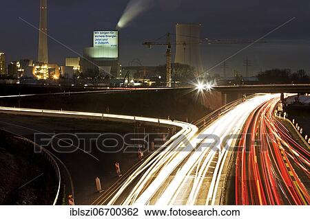 Stock Image - Light traces in the evening on the motorway A 43 with the Steag power plant Herne in the background, Herne, Ruhr area, North Rhine-Westphalia, Germany, Europe. Fotosearch