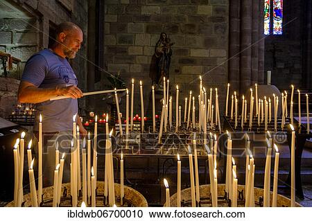 Man lighting a votive candle, devotional candles, Notre Dame Church, Saint-Jean-Pied-de-Port, Camino de Santiago, Via Podiensis, Camino Francés, Pyrenees, Département Pyrénées-Atlantiques. Region Nouvelle-Aquitaine, Pays Basque, Basque Country,... View Large Photo Image Stock Image - Man lighting a votive candle, devotional candles, Notre Dame Church, Saint-Jean-Pied-de-Port, Camino de Santiago, Via Podiensis, Camino Francés, Pyrenees, Département Pyrénées-Atlantiques. Region Nouvelle-Aquitaine, Pays Basque, Basque Country,.... Fotosearch