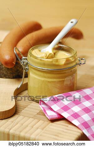 Stock Image - Mustard jar, mustard, sausages on bread, Vienna sausages, chopping board, spice. Fotosearch