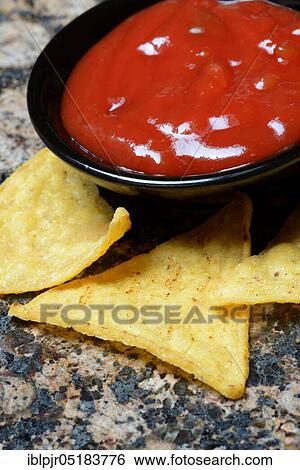 Stock Photograph - Nachos with tomato dip, snack, starter, chip, chips, salsa, dip sauce, dip sauce, corn chips. Fotosearch