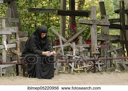 Stock Photograph - Nun watchin pictures in camera, sacred mountain Grabarka, Swieta Gora Garbarka, Poland, Europe. Fotosearch