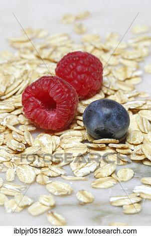 Stock Image - Oat flakes and berries, raspberries, blueberries, oats. Fotosearch