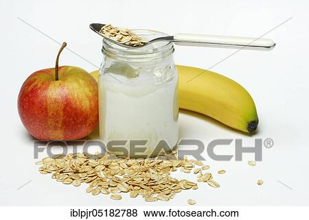 Stock Photo - Oat flakes (Avena sativa) Glass of yoghurt, apple, banana, oats, dairy products. Fotosearch