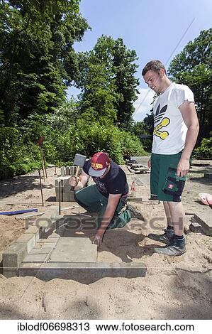 Stock Image - Paving work, carried out by trainees as garden and landscape builders. Fotosearch