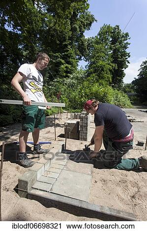 Paving work, carried out by trainees as garden and landscape builders View Large Photo Image Stock Image - Paving work, carried out by trainees as garden and landscape builders. Fotosearch