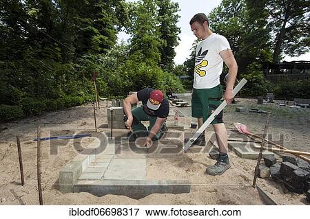 Stock Photo - Paving work, carried out by trainees as garden and landscape builders. Fotosearch