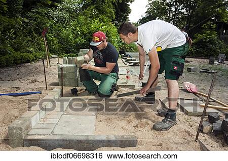 Stock Photograph - Paving work, carried out by trainees as garden and landscape builders. Fotosearch