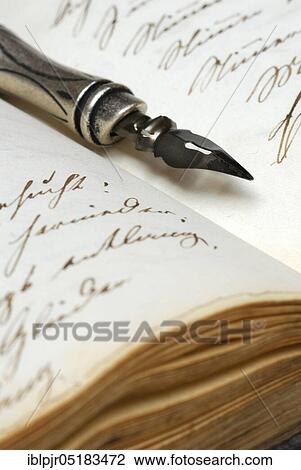 Stock Image - Pen with nib on book, old writing, ink, diary. Fotosearch