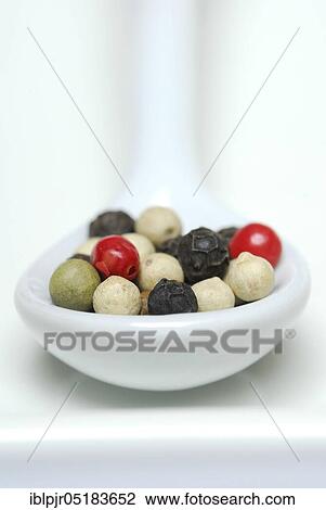 Stock Image - Peppercorns in porcelain spoon, peppercorns, red, white, black and green pepper. Fotosearch