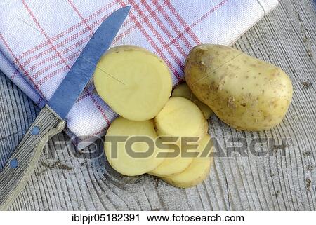Stock Image - Potato slices and potatoes, Charlotte variety, knife. Fotosearch