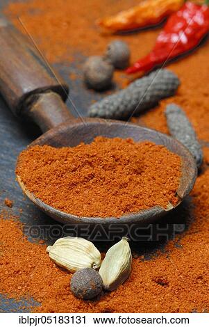Stock Image - Powder in a wooden spoon (Berbere), spice mixture of chili, pimento, cardamom, pepper, -spice mixture. Fotosearch