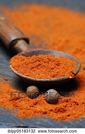 Stock Image - Powder in a wooden spoon (Berbere), spice mixture of chili, pimento, cardamom, pepper, allspice seeds and spice mixture. Fotosearch