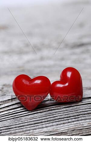 Stock Image - Red hearts on old wood. Fotosearch