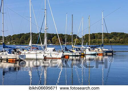 Stock Image - Sailing yachts reflected in the harbour of Rostock, Rostock, Baltic Sea, Mecklenburg-Vorpommern, East Germany. Fotosearch