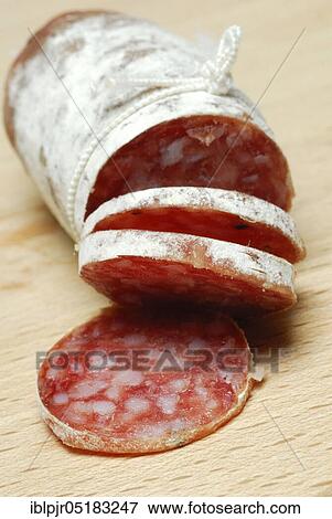 Stock Photo - Salametti on wooden board, sausages, long-life sausage, salami. Fotosearch