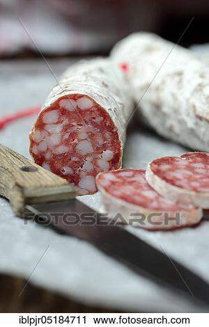 Stock Image - Salami, salametti with kitchen knife, Dauerwurst, Dauerwurst. Fotosearch