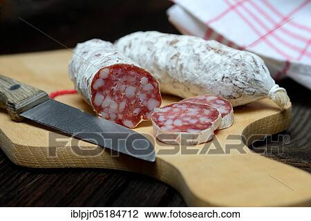 Stock Image - Salami, salametti with kitchen knife, on wooden board, Dauerwurst, Dauerwürste. Fotosearch
