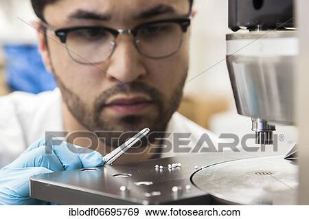 Scientists during their research work on a tablet press at the Institute for Pharmaceutical Technology and Biopharmacy at Heinrich-Heine-University Düsseldorf, North Rhine-Westphalia, Germany, Europe View Large Photo Image Stock Photo - Scientists during their research work on a tablet press at the Institute for Pharmaceutical Technology and Biopharmacy at Heinrich-Heine-University Düsseldorf, North Rhine-Westphalia, Germany, Europe. Fotosearch
