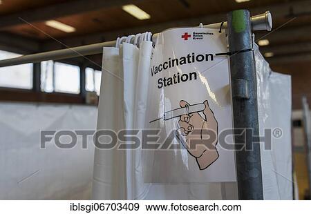 Stock Photo - Sign with English inscription VACCINATION STATION hangs in a vaccination center in Erding, Bavaria, Germany, Europe. Fotosearch