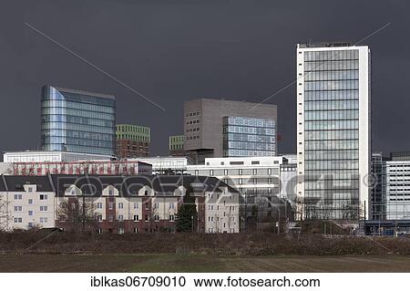 Stock Image - Skyline Düsseldorfer Medienhafen, skyscrapers The Sign, Win Win, Dock, Media Tower, in front old residential buildings, stormy sky, Düsseldorf, North Rhine-Westphalia, Germany, Europe. Fotosearch