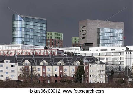 Stock Image - Skyline Düsseldorfer Medienhafen, skyscrapers The Sign, Win Win, dock, in front old residential buildings, thunderstorm sky, Düsseldorf, North Rhine-Westphalia, Germany, Europe. Fotosearch