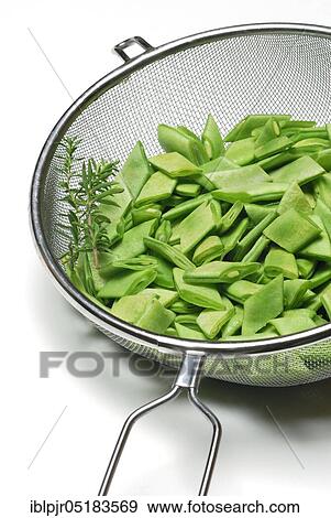 Stock Photo - Sliced broad beans with savory in kitchen sieve. Fotosearch