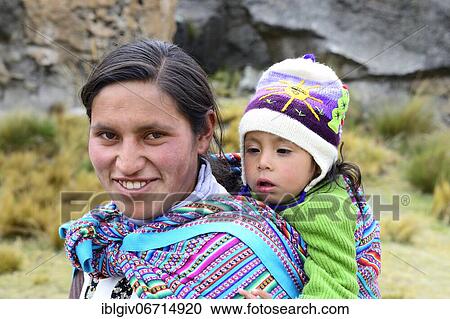 Stock Image - Smiling indigenous woman with falling asleep infant on her back, Junín province, Peru, South America. Fotosearch