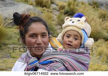 Stock Image - Smiling indigenous woman with infant on her back, Junín province, Peru, South America. Fotosearch