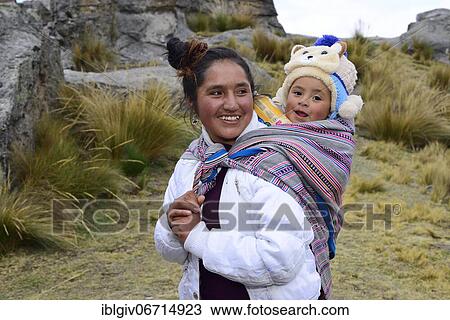 Stock Image - Smiling indigenous woman with infant on her back, Junín province, Peru, South America. Fotosearch