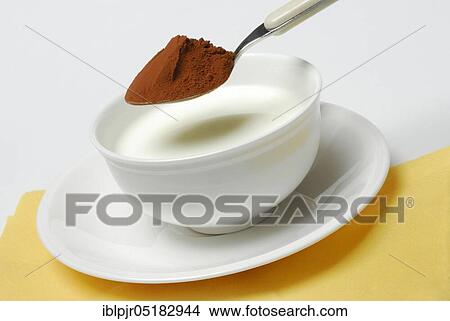 Picture - Spoon of cocoa powder is put into cup with milk, cocoa drink, milk, milk products, cocoa. Fotosearch