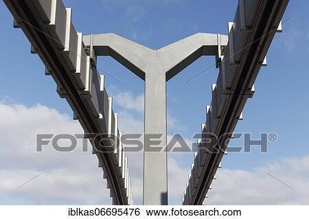 Stock Photograph - Steel and concrete monorail track against blue sky, Skytrain, Düsseldorf Airport, North Rhine-Westphalia, Germany, Europe. Fotosearch
