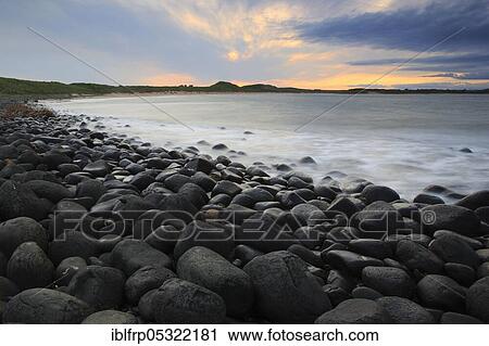 Stock Image - Stony beach in Northumberland, Great Britain. Fotosearch