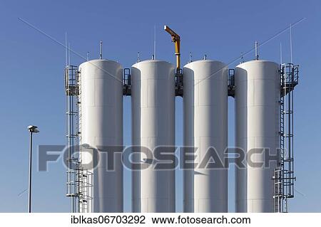 Stock Image - Storage tanks for de-icing fluid, painted white, against blue sky, Düsseldorf Airport, North Rhine-Westphalia, Germany, Europe. Fotosearch