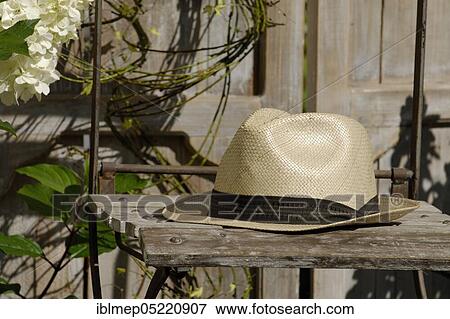 Straw hat on garden chair View Large Photo Image Stock Photo - Straw hat on garden chair. Fotosearch