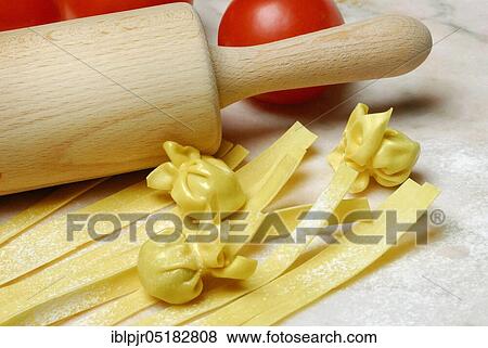 Stock Photo - Tagliatelle and filled dough beads, ribbon noodles, pearl al basilico, pasta, pasta, dough beads, rolling pin. Fotosearch